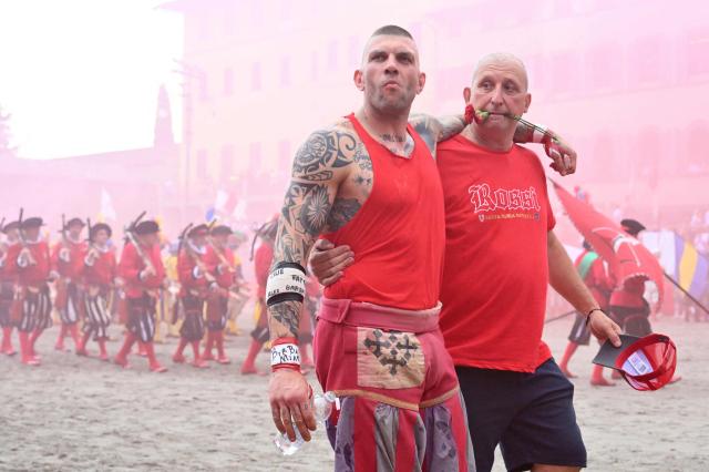 Rossi players arrive for the final match of the Calcio Storico Fiorentino, a traditional 16th century renaissance ball game, between the Azzurri of Santa Croce and the Rossi of Santa Maria Novella, at Piazza Santa Croce in Florence on June 24, 2026. (Photo by Alberto PIZZOLI / AFP)