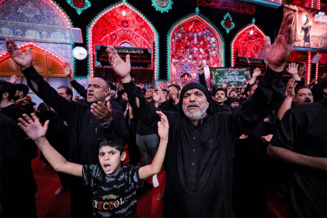 Shia Muslim devotees attend a mourning procession at the Shrine of Imam Hussein in Iraq's holy city of Karbala on June 24, 2026, coinciding with the the ninth day of the Muslim holy month of Muharram, the eve of Ashura (tenth day) which marks the seventh century killing of the Prophet Mohamed's grandson the Imam Hussein. (Photo by AHMAD AL-RUBAYE / AFP)