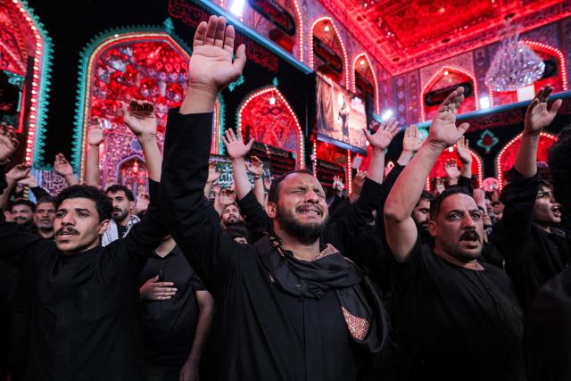 Shia Muslim devotees attend a mourning procession at the Shrine of Imam Hussein in Iraq's holy city of Karbala on June 24, 2026, coinciding with the the ninth day of the Muslim holy month of Muharram, the eve of Ashura (tenth day) which marks the seventh century killing of the Prophet Mohamed's grandson the Imam Hussein. (Photo by AHMAD AL-RUBAYE / AFP)