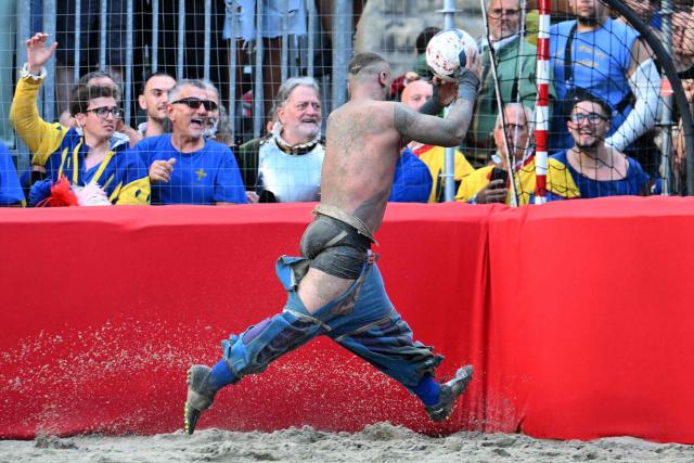 A player runs with a ball during the final match of the Calcio Storico Fiorentino, a traditional 16th century renaissance ball game, between the Azzurri of Santa Croce and the Rossi of Santa Maria Novella, at Piazza Santa Croce in Florence on June 24, 2026. (Photo by Alberto PIZZOLI / AFP)