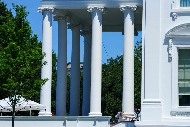 Workers with the US National Park Service work on the columns of the White House North Portico as President Donald Trump returns to the White House after a lunch meeting with Senate Republicans at the US Capitol in Washington, DC, on June 24, 2026. President Trump said Wednesday he will refuse to sign a landmark housing bill, passed by Congress with broad bipartisan support, until lawmakers approve legislation that would overhaul American elections and restrict voter registration. (Photo by Aaron Schwartz / AFP)