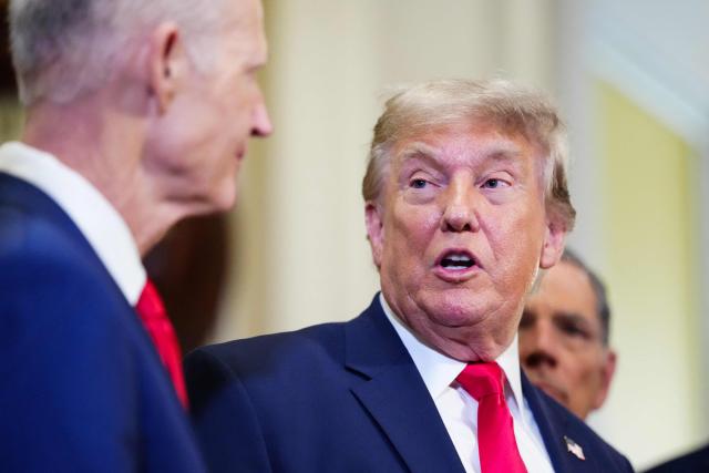 (L/R) US Senator Rick Scott, Republican from Florida, looks on as President Donald Trump speaks to the press after a lunch meeting with Senate Republicans at the US Capitol in Washington, DC, on June 24, 2026. President Trump said Wednesday he will refuse to sign a landmark housing bill, passed by Congress with broad bipartisan support, until lawmakers approve legislation that would overhaul American elections and restrict voter registration. (Photo by Aaron Schwartz / AFP)