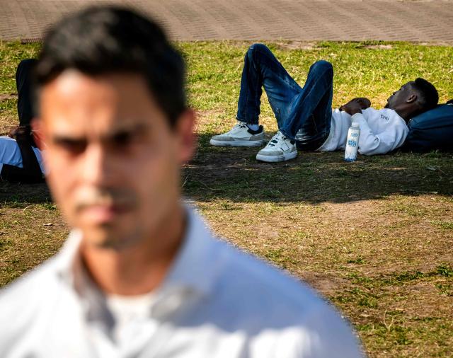 A man lies down as Netherlands' Prime Minister Rob Jetten attends a visit to the IND registration centre in Ter Apel on June 24, 2026. (Photo by Remko de Waal / ANP / AFP) / Netherlands OUT