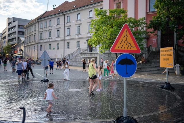 Pedestrians cool off at “The area with Ljubljana’s own weather” in Preseren Square in Ljubljana on June 24, 2026. Europe struggled to cope with a record-breaking heatwave on June 24, 2026, with at least 94 million people expected to experience temperatures above 35C, most of them in France and Spain. (Photo by Jure MAKOVEC / AFP)