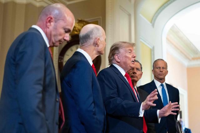 US President Donald Trump (C), alongside (L/R) Senator Mike Lee, Republican from Utah, Senator Rick Scott, Republican from Florida, Senator John Barrasso, Republican from Wyoming, and Senate Majority Leader John Thune, Republican from South Dakota, speaks to the press after a lunch meeting with Senate Republicans at the US Capitol in Washington, DC, on June 24, 2026. President Trump said Wednesday he will refuse to sign a landmark housing bill, passed by Congress with broad bipartisan support, until lawmakers approve legislation that would overhaul American elections and restrict voter registration. (Photo by Aaron Schwartz / AFP)