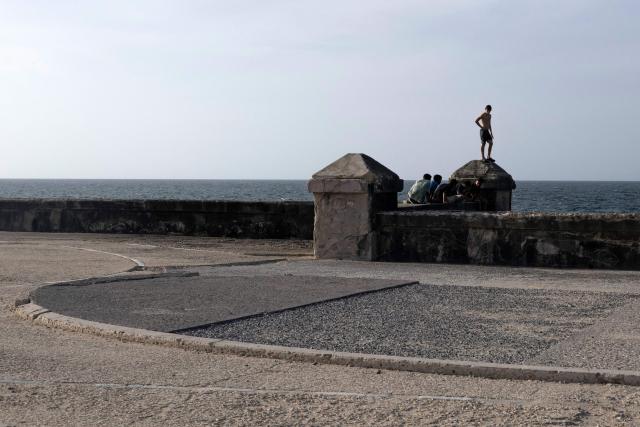 Young people rest on Havana's Malecon, on June 23, 2026. (Photo by Pablo PORCIUNCULA / AFP)