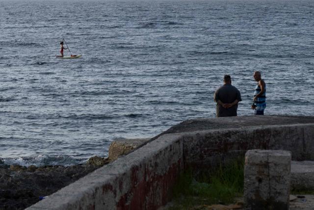 People rest on the seaside promenade at the Miramar neighborhood in Havana, on June 23, 2026. (Photo by Pablo PORCIUNCULA / AFP)