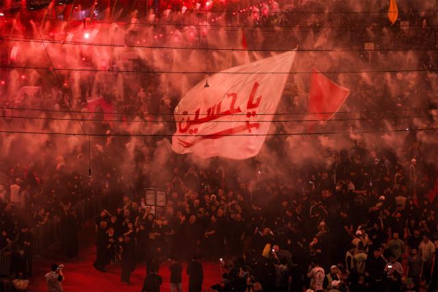 Shia Muslim devotees gather for a mourning ritual near the Shrine of Imam Abbas in Iraq's holy city of Karbala on June 24, 2026, coinciding with the the ninth day of the Muslim holy month of Muharram, the eve of Ashura (tenth day) which marks the seventh century killing of the Prophet Mohamed's grandson the Imam Hussein. (Photo by AHMAD AL-RUBAYE / AFP)