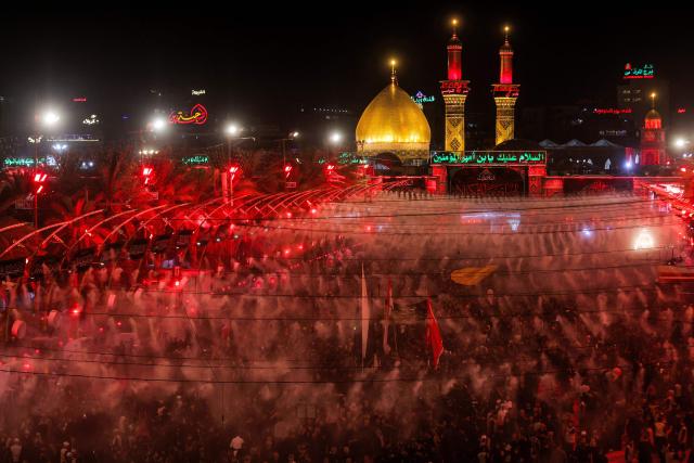 Shia Muslim devotees gather for a mourning ritual near the Shrine of Imam Abbas in Iraq's holy city of Karbala on June 24, 2026, coinciding with the the ninth day of the Muslim holy month of Muharram, the eve of Ashura (tenth day) which marks the seventh century killing of the Prophet Mohamed's grandson the Imam Hussein. (Photo by AHMAD AL-RUBAYE / AFP)