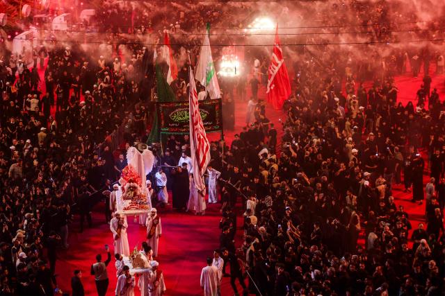 Shia Muslim devotees gather for a mourning ritual near the Shrine of Imam Abbas in Iraq's holy city of Karbala on June 24, 2026, coinciding with the the ninth day of the Muslim holy month of Muharram, the eve of Ashura (tenth day) which marks the seventh century killing of the Prophet Mohamed's grandson the Imam Hussein. (Photo by AHMAD AL-RUBAYE / AFP)