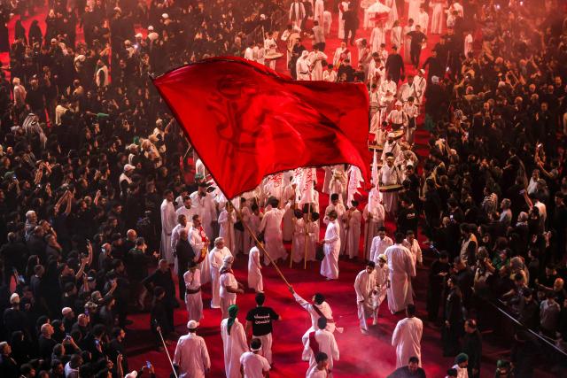 Shia Muslim devotees gather for a mourning ritual near the Shrine of Imam Abbas in Iraq's holy city of Karbala on June 24, 2026, coinciding with the the ninth day of the Muslim holy month of Muharram, the eve of Ashura (tenth day) which marks the seventh century killing of the Prophet Mohamed's grandson the Imam Hussein. (Photo by AHMAD AL-RUBAYE / AFP)