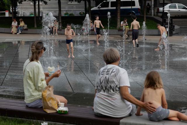 Children play in a fountain in Kyiv on June 24, 2026, amid the Russian invasion of Ukraine. Europe struggled to cope with a record-breaking heatwave on June 24, 2026, with at least 94 million people expected to experience temperatures above 35C, most of them in France and Spain. (Photo by Tetiana DZHAFAROVA / AFP)