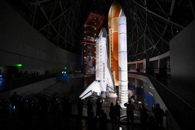 People view NASA’s Space Shuttle Endeavour as it stands stacked complete in a launch-ready vertical display with the ET-94 External Fuel Tank and a pair of Solid Rocket Boosters (SRBs) inside the Samuel Oschin Shuttle Gallery at the California Science Center in Los Angeles, California on June 24, 2026. The Space Shuttle Endeavour exhibit will open on November 13, 2026 as part of a 200,000-square-foot expansion with the Samuel Oschin Air and Space Center. (Photo by Patrick T. Fallon / AFP)