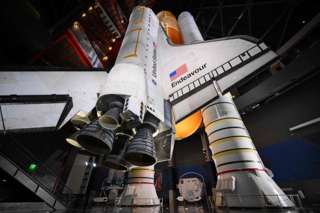 NASA’s Space Shuttle Endeavour stands stacked complete in a launch-ready vertical display with the ET-94 External Fuel Tank and a pair of Solid Rocket Boosters (SRBs) inside the Samuel Oschin Shuttle Gallery at the California Science Center in Los Angeles, California on June 24, 2026. The Space Shuttle Endeavour exhibit will open on November 13, 2026 as part of a 200,000-square-foot expansion with the Samuel Oschin Air and Space Center. (Photo by Patrick T. Fallon / AFP)