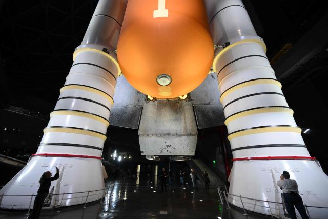 People take pictures of NASA’s Space Shuttle Endeavour as it stands stacked complete in a launch-ready vertical display with the ET-94 External Fuel Tank and a pair of Solid Rocket Boosters (SRBs) inside the Samuel Oschin Shuttle Gallery at the California Science Center in Los Angeles, on June 24, 2026. The Space Shuttle Endeavour exhibit will open on November 13, 2026 as part of a 200,000-square-foot expansion with the Samuel Oschin Air and Space Center. (Photo by Patrick T. Fallon / AFP)