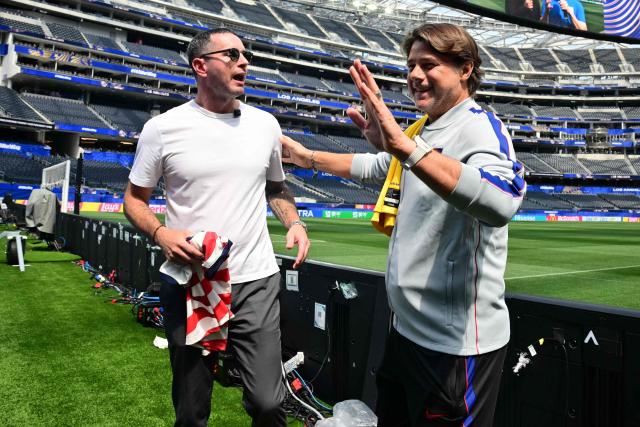 Los Angeles Lakers head coach JJ Redick (L) and US Argentine head coach Mauricio Pochettino (R) swap jerseys at Los Angeles Stadium on June 24, 2026, on the eve of the 2026 World Cup football tournament Group D football match against Turkey and the USA. (Photo by Frederic J. Brown / AFP)