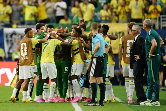 Brazil's forward #07 Vinicius Junior celebrates with teammates after scoring his team's second goal during the 2026 World Cup Group C football match between Scotland and Brazil at the Miami Stadium in Miami Gardens on June 24, 2026.  (Photo by CHANDAN KHANNA / AFP)