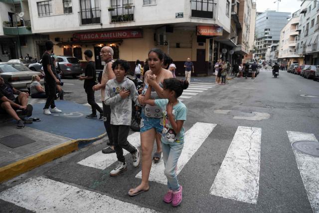 People remain on a street following an earthquake in Caracas on June 24, 2026. A magnitude 7.1 earthquake struck Venezuela on Wednesday, the United States Geological Survey (USGS) reported, triggering panic in Caracas, according to AFP journalists. The tremor, which was followed by several aftershocks, was also felt in Colombia. (Photo by Manaure QUINTERO / AFP)