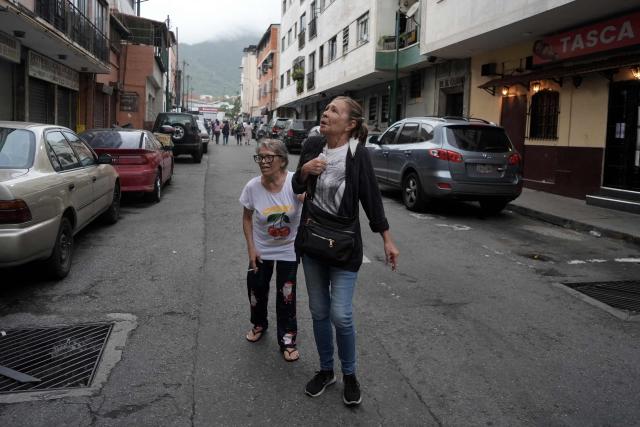 Women react in the street after an earthquake in Caracas on June 24, 2026. A magnitude 7.1 earthquake struck Venezuela on Wednesday, the United States Geological Survey (USGS) reported, triggering panic in Caracas, according to AFP journalists. The tremor, which was followed by several aftershocks, was also felt in Colombia. (Photo by Manaure QUINTERO / AFP)