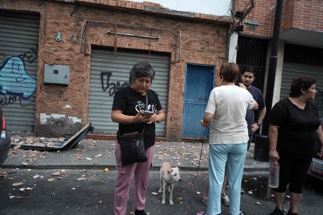 People remain in the street after an earthquake in Caracas on June 24, 2026. A magnitude 7.1 earthquake struck Venezuela on Wednesday, the United States Geological Survey (USGS) reported, triggering panic in Caracas, according to AFP journalists. The tremor, which was followed by several aftershocks, was also felt in Colombia. (Photo by Manaure QUINTERO / AFP)