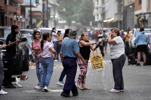 People remain on a street following an earthquake in Caracas on June 24, 2026. A magnitude 7.1 earthquake struck Venezuela on Wednesday, the United States Geological Survey (USGS) reported, triggering panic in Caracas, according to AFP journalists. The tremor, which was followed by several aftershocks, was also felt in Colombia. (Photo by Manaure Quintero / AFP)