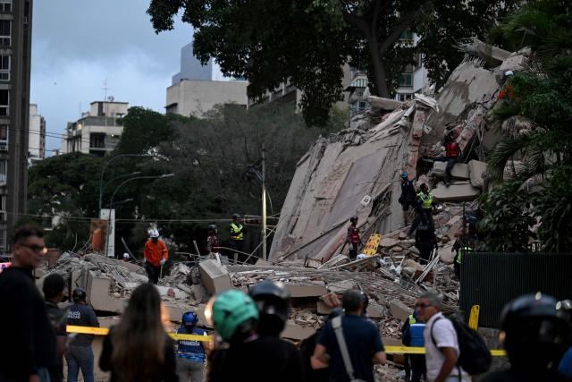 Rescuers search for victims in a collapsed building following an earthquake in Caracas on June 24, 2026. A magnitude 7.1 earthquake struck Venezuela on Wednesday, the United States Geological Survey (USGS) reported, triggering panic in Caracas, according to AFP journalists. The tremor, which was followed by several aftershocks, was also felt in Colombia. (Photo by Juan BARRETO / AFP)