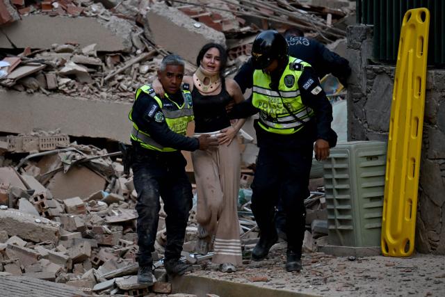 Municipal police officers evacuate an injured victim from a collapsed building following an earthquake in Caracas on June 24, 2026. A magnitude 7.1 earthquake struck Venezuela on Wednesday, the United States Geological Survey (USGS) reported, triggering panic in Caracas, according to AFP journalists. The tremor, which was followed by several aftershocks, was also felt in Colombia. (Photo by Juan BARRETO / AFP)