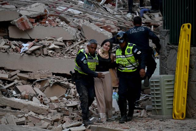 Municipal police officers evacuate an injured victim from a collapsed building following an earthquake in Caracas on June 24, 2026. A magnitude 7.1 earthquake struck Venezuela on Wednesday, the United States Geological Survey (USGS) reported, triggering panic in Caracas, according to AFP journalists. The tremor, which was followed by several aftershocks, was also felt in Colombia. (Photo by Juan BARRETO / AFP)