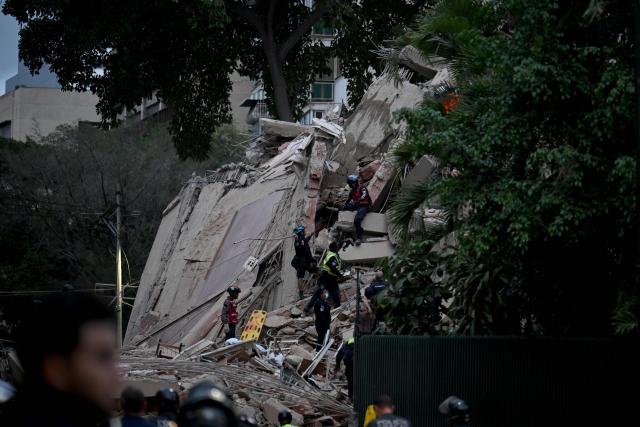 Rescuers search for victims in a collapsed building following an earthquake in Caracas on June 24, 2026. A magnitude 7.1 earthquake struck Venezuela on Wednesday, the United States Geological Survey (USGS) reported, triggering panic in Caracas, according to AFP journalists. The tremor, which was followed by several aftershocks, was also felt in Colombia. (Photo by Juan BARRETO / AFP)