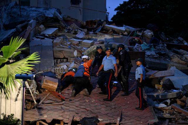 First responders search for victims in a collapsed building following an earthquake in Caracas on June 24, 2026. A magnitude 7.1 earthquake struck Venezuela on Wednesday, the United States Geological Survey (USGS) reported, triggering panic in Caracas, according to AFP journalists. The tremor, which was followed by several aftershocks, was also felt in Colombia. (Photo by Juan BARRETO / AFP)