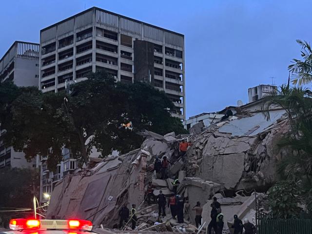 Rescuers search for victims in a collapsed building following an earthquake in Caracas on June 24, 2026. A magnitude 7.1 earthquake struck Venezuela on Wednesday, the United States Geological Survey (USGS) reported, triggering panic in Caracas, according to AFP journalists. The tremor, which was followed by several aftershocks, was also felt in Colombia. (Photo by Manaure QUINTERO / AFP)