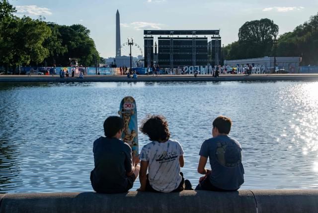 People wait at the base of the reflecting pool at the US Capitol for the fly over the National Mall during a kick-off celebration for the "Great American State Fair" on the National Mall in Washington, DC, June 24, 2026. The "Great American State Fair" will be held from June 25 to July 10, 2026, to celebrate the 250th anniversary of US independence. (Photo by Ken Cedeno / AFP)