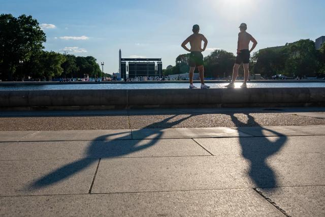 People wait at the base of the reflecting pool at the US Capitol for the fly over the National Mall during a kick-off celebration for the "Great American State Fair" on the National Mall in Washington, DC, June 24, 2026. The "Great American State Fair" will be held from June 25 to July 10, 2026, to celebrate the 250th anniversary of US independence. (Photo by Ken Cedeno / AFP)