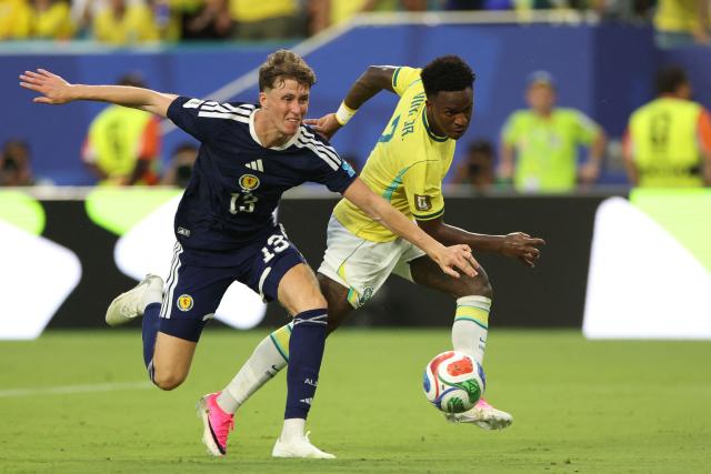 Scotland's defender #13 Jack Hendry and Brazil's forward #07 Vinicius Junior fight for the ball during the 2026 World Cup Group C football match between Scotland and Brazil at the Miami Stadium in Miami Gardens on June 24, 2026.  (Photo by PATRICIA DE MELO MOREIRA / AFP)