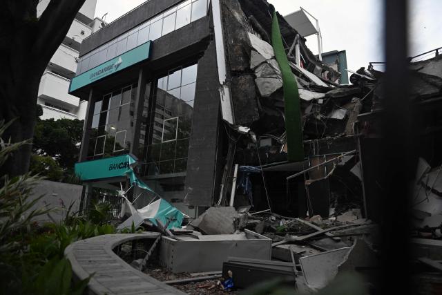 A Bancaribe bank branch is seen damaged following an earthquake in Caracas on June 24, 2026. A magnitude 7.1 earthquake struck Venezuela on Wednesday, the United States Geological Survey (USGS) reported, triggering panic in Caracas, according to AFP journalists. The tremor, which was followed by several aftershocks, was also felt in Colombia. (Photo by Juan BARRETO / AFP)