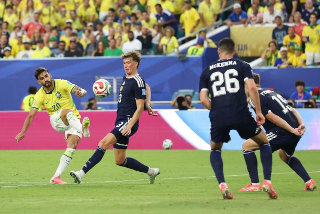 Brazil's midfielder #20 Lucas Paqueta shoots past Scotland's midfielder #23 Kenny McLean during the 2026 World Cup Group C football match between Scotland and Brazil at the Miami Stadium in Miami Gardens on June 24, 2026.  (Photo by PATRICIA DE MELO MOREIRA / AFP)