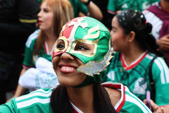 A masked Mexican football attends the FIFA Fan Fest in Mexico City ahead of the FIFA World Cup 2026 match between Mexico and Czechia, in Mexico City on June 24, 2026. (Photo by Claudia Rosel / AFP)