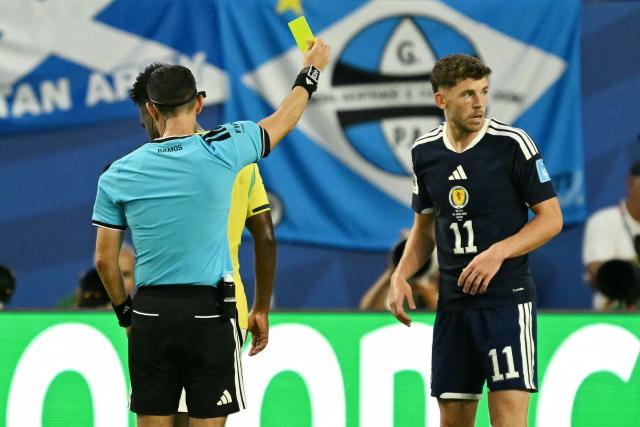 Mexican referee Cesar Ramos shows a yellow card to Scotland's forward #11 Ryan Christie during the 2026 World Cup Group C football match between Scotland and Brazil at the Miami Stadium in Miami Gardens on June 24, 2026.  (Photo by CHANDAN KHANNA / AFP)