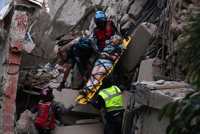 Rescue workers carry a person on a stretcher out of a collapsed building following an earthquake in Caracas on June 24, 2026. A magnitude 7.1 earthquake struck Venezuela on Wednesday, the United States Geological Survey (USGS) reported, triggering panic in Caracas, according to AFP journalists. The tremor, which was followed by several aftershocks, was also felt in Colombia. (Photo by Juan BARRETO / AFP)