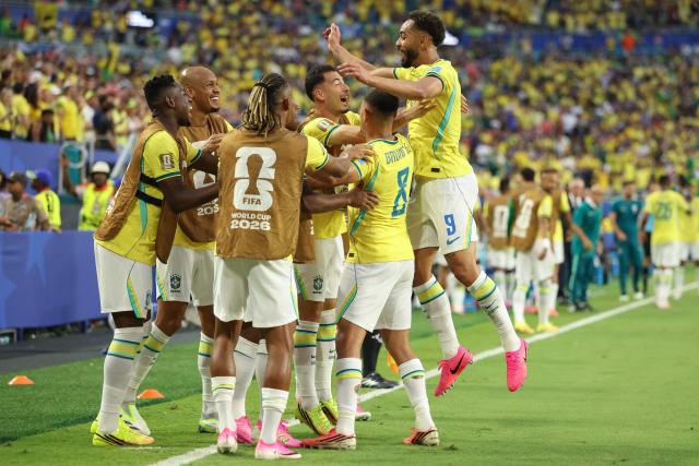 Brazil's forward #09 Matheus Cunha celebrates with teammates after scoring his team's third goal during the 2026 World Cup Group C football match between Scotland and Brazil at the Miami Stadium in Miami Gardens on June 24, 2026.  (Photo by PATRICIA DE MELO MOREIRA / AFP)