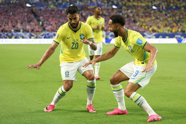 Brazil's forward #09 Matheus Cunha celebrates with teammate midfielder #20 Lucas Paqueta after scoring his team's third goal during the 2026 World Cup Group C football match between Scotland and Brazil at the Miami Stadium in Miami Gardens on June 24, 2026.  (Photo by PATRICIA DE MELO MOREIRA / AFP)