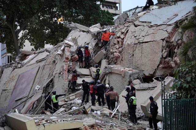 Rescuers search for victims in a collapsed building following an earthquake in Caracas on June 24, 2026. A magnitude 7.1 earthquake struck Venezuela on Wednesday, the United States Geological Survey (USGS) reported, triggering panic in Caracas, according to AFP journalists. The tremor, which was followed by several aftershocks, was also felt in Colombia. (Photo by Manaure Quintero / AFP)