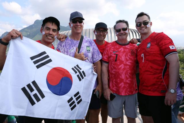 South Korean fans pose for a photo as they arrive to watch the 2026 World Cup Group A football match between South Africa and South Korea at the Monterrey Stadium in Guadalupe, Mexico, on June 24, 2026.  (Photo by Julio Cesar AGUILAR / AFP)