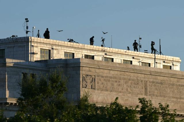 Snipers with the Secret Service are seen atop the Department of Agriculture ahead of a speech by the US president during the kick-off celebration for the "Great American State Fair" on the National Mall in Washington, DC, June 24, 2026. The "Great American State Fair" will be held from June 25 to July 10, 2026, to celebrate the 250th anniversary of US independence. (Photo by Oliver Contreras / AFP)