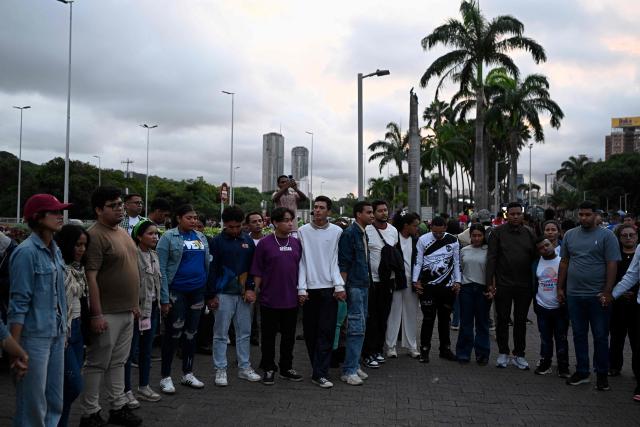 People pray in the street after an earthquake in Caracas on June 24, 2026. A magnitude 7.1 earthquake struck Venezuela on Wednesday, the United States Geological Survey (USGS) reported, triggering panic in Caracas, according to AFP journalists. The tremor, which was followed by several aftershocks, was also felt in Colombia. (Photo by Federico PARRA / AFP)
