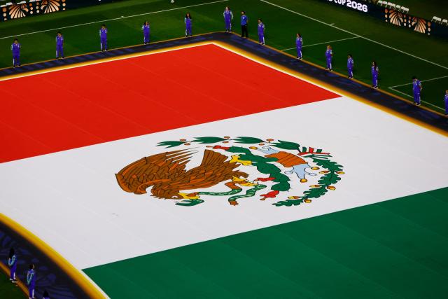 A Mexican flag is displayed on the pitch ahead of the 2026 World Cup Group A football match between the Czech Republic and Mexico at the Mexico City Stadium in Mexico City on June 24, 2026.  (Photo by Rodrigo Oropeza / AFP)