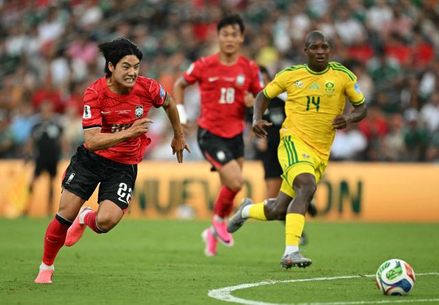 South Korea's defender #22 Seol Young-woo runs with the ball followed by South Africa's defender #14 Mbekezeli Mbokazi during the 2026 World Cup Group A football match between South Africa and South Korea at the Monterrey Stadium in Guadalupe, Mexico, on June 24, 2026.  (Photo by Yuri CORTEZ / AFP)