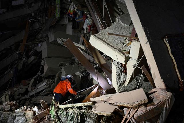 A rescuer searches through the rubble of a collapsed building following an earthquake in Caracas on June 24, 2026. A magnitude 7.1 earthquake struck Venezuela on Wednesday, the United States Geological Survey (USGS) reported, triggering panic in Caracas, according to AFP journalists. The tremor, which was followed by several aftershocks, was also felt in Colombia. (Photo by Federico PARRA / AFP)