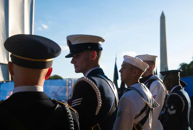 Service members listen to the speakers on the stage during a kick-off celebration for the "Great American State Fair" on the National Mall in Washington, DC, June 24, 2026. The "Great American State Fair" will be held from June 25 to July 10, 2026, to celebrate the 250th anniversary of US independence. (Photo by Matthew Hatcher / AFP)
