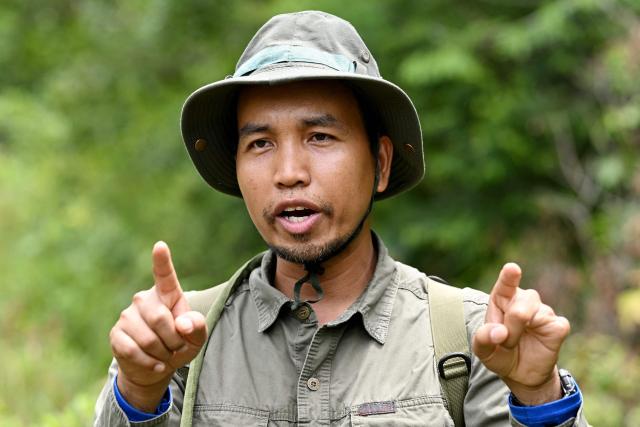 This photo taken on June 10, 2026 shows Ratha Sor, Biodiversity and Science Manager of Conservation International Cambodia, speaking to AFP in the Cardamom National Park in Koh Kong province. Above the patter of rain cascading through the jungle canopy comes the haunting call of a pileated gibbon singing to fend off intruders in Cambodia's Cardamom Mountains. (Photo by TANG CHHIN Sothy / AFP) / To go with 'CAMBODIA-CONSERVATION-ENVIRONMENT-ANIMAL-SCIENCE-FORESTS,FOCUS' by Sara HUSSEIN and Suy SE
